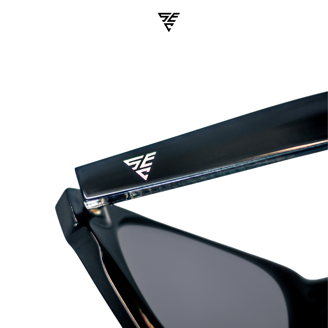 Embodying a classic unisex style, these all-black rectangular block sunglasses offer a timeless elegance that effortlessly exudes sophistication. The silver metal accent discreetly placed inside the arms adds a touch of refinement, unveiling a hidden world of opulence. A perfect blend of exclusivity and grace, these sunglasses offer the perfect accessory to give off an expensive and elegant look.